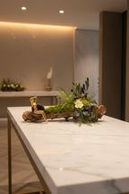 Composition végétale stabilisée sur racine de vigne avec mousse, fougères, eucalyptus et fleur blanche – décoration végétale artisanale