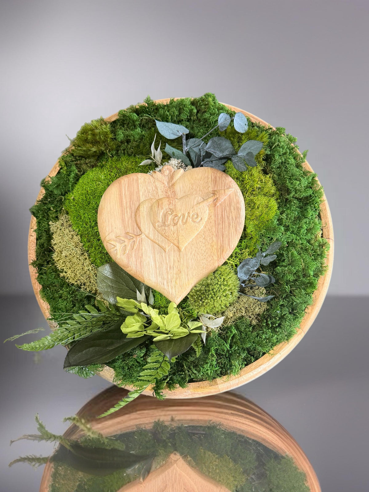 Centre de table végétal stabilisé 40 cm avec cœur en bois love, mousse verte et feuillages naturels